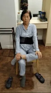 Patient doing kneeling wall stretches during physiotherapy rehabilitation session